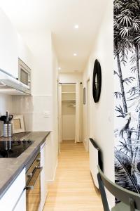 een keuken met witte muren en een zwart aanrecht bij Le Tropical - Beau logement centre - Gare - Tram in Le Mans
