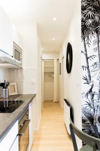 a kitchen with white walls and a black counter top at Le Tropical - Beau logement centre - Gare - Tram in Le Mans