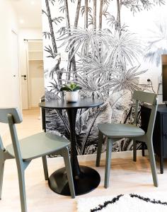 een eetkamer met een tafel en 2 stoelen bij Le Tropical - Beau logement centre - Gare - Tram in Le Mans