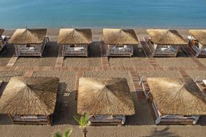 an overhead view of a group of straw umbrellas on the beach at Titanic Deluxe Lara in Lara