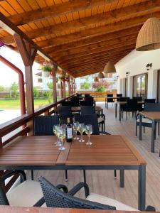 a wooden table with wine glasses on a patio at Pensiunea Taisia in Murighiol