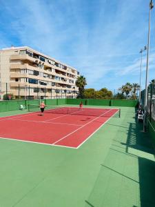2 personnes jouant au tennis sur un court dans l'établissement Apartament Cabo Cervera Costa del Alba, à Torrevieja