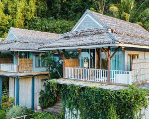 une femme debout sur la terrasse couverte d'une maison dans l'établissement Baan Phuvara Retreat - Romantic Jacuzzi Mountain View Villas, à Ao Nang Beach