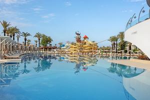 a large pool at a resort with a slide at Titanic Deluxe Lara in Lara