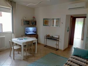 uma sala de estar com uma mesa branca e uma televisão em appartamento incantevole a due passi dal mare a Viserbella vicino fiera Rimini em Rimini