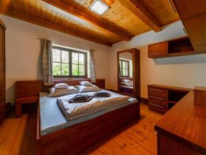 a bedroom with a large bed and a wooden ceiling at Holiday Home Kunějov by Interhome in Člunek