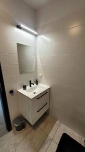 a white bathroom with a sink and a mirror at LOFT pri parku in Banská Bystrica