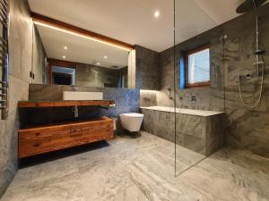 a bathroom with a sink and a toilet and a shower at Luxury Chalet Engedi in Saas-Fee