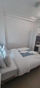 a bed with white sheets and pillows in a room at Hotel Aboukir in Paris