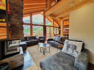 a living room with a couch and a fireplace at Luxury Chalet Engedi in Saas-Fee