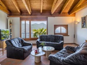 ein Wohnzimmer mit Ledermöbeln und einem großen Fenster in der Unterkunft Holiday Home Casa Porta by Interhome in Brissago