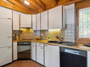 eine Küche mit weißen Schränken und einem Waschbecken in der Unterkunft Holiday Home Casa Porta by Interhome in Brissago