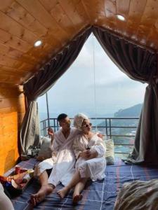 a man and a woman sitting on the bed of a boat at Tam Đảo Xanh Homestay - Venuestay in Vĩnh Phúc