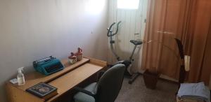 Zimmer mit einem Schreibtisch, einem Stuhl und einem Telefon. in der Unterkunft Casa 3 habitaciones in General Alvear