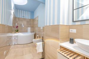 une salle de bain avec une baignoire, un lavabo et des toilettes dans l'établissement City Gate - luxury suites, à Bari 33 autres photos