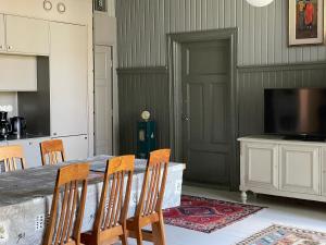 a dining room with a table with chairs and a television at Stationmaster's studio in Porvoo