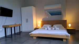 a bedroom with a bed with two pillows and a television at Light blue studios 2 in Poulithra