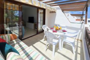 a white table and chairs on a balcony at Los Helechos A1, central 2 bed PDC in Puerto del Carmen