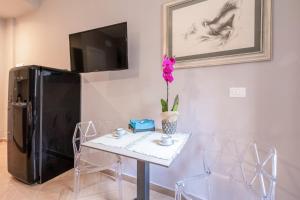 a dining room with a table and a black refrigerator at City Gate - luxury suites in Bari