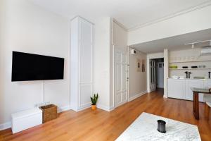 uma sala de estar branca com uma televisão de ecrã plano na parede em Charming Bright Modern Design 1bd Home #282 em Istambul