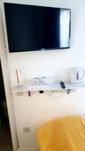 TV de pantalla plana colgada en una pared blanca en The Broadway Rooms, en Leicester