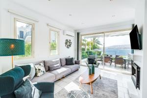 un soggiorno con un divano e una TV di Beach Front Villa Aqua Blu by Ezoria Villas a Coral Bay