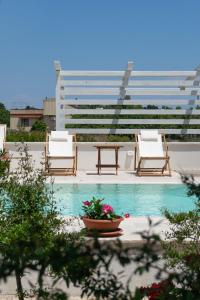 a group of chairs and a table next to a pool at Kalinifta - Io parto Io arrivo in Tricase