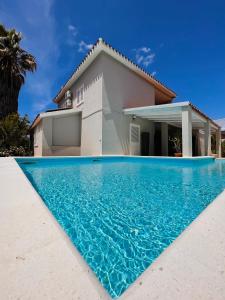 uma casa com piscina em frente a uma casa em La Costa B&B em Flumini di Quartu