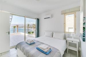 una camera da letto con un letto con vista sull'oceano di Beach Front Villa Aqua Blu by Ezoria Villas a Coral Bay