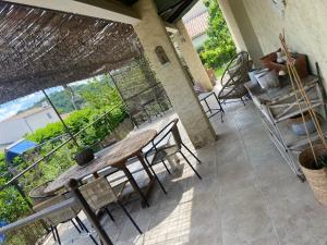 a patio with a table and chairs on a balcony at La pastourelle villa 6 couchages au calme in Forcalquier