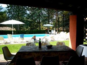 einen Tisch mit Gläsern und eine Flasche Wein neben einem Pool in der Unterkunft Villa (home B) — Pool — Lake Idro in Vesta