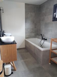 ein Badezimmer mit einer Badewanne und einem Waschbecken in der Unterkunft Charmante villa avec studio indépendant in Vendays-Montalivet