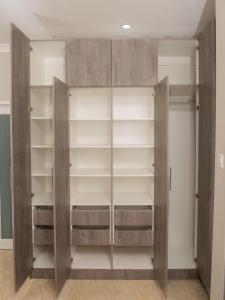 un armario con puertas y estanterías de madera en JC Apartments, en Ndola