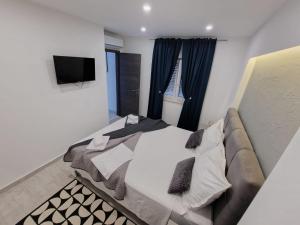 - une chambre avec un grand lit et une télévision dans l'établissement Casa Bella, à Split