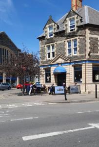 a building with a sign in front of it on a street at Large Three Bedroom Apartment with Roof Terrace Near City Centre in Cardiff