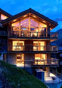 a house with a large deck at night at Luxury Chalet Engedi in Saas-Fee