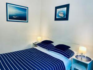 a bedroom with a bed with blue and white stripes at Apartment Blue&Green in Kostrena