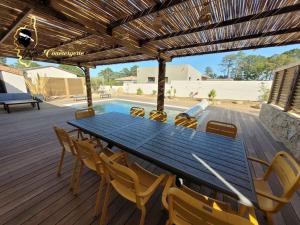 - une table et des chaises sur une terrasse avec piscine dans l'établissement Villa du Soleil 8 pers piscine chauffée, à Lecci