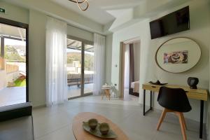 a living room with a table and a large window at Swan Paradise Residences in Loutra Oraias Elenis