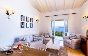 a living room with a table and chairs and a view of the ocean at Villa Nafsika in Ágios Stéfanos