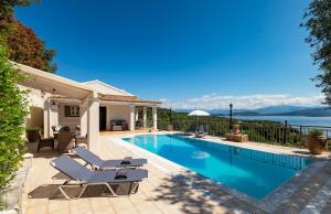 a swimming pool with two lounge chairs next to a house at Villa Nafsika in Ágios Stéfanos