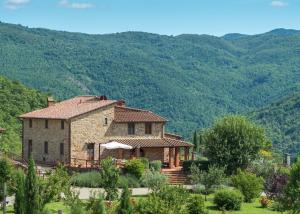 una gran casa de piedra con montañas en el fondo en Villa Mille Desideri, en Anghiari