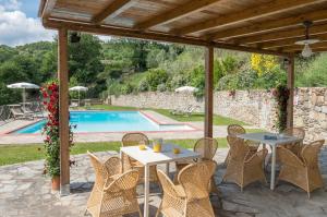 Un patio con mesas y sillas y una piscina. en Villa Mille Desideri, en Anghiari