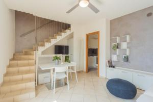 a living room with a staircase and a white table and chairs at Blue Bliss Apartment by Rent All Como in Colonno