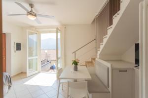 a living room with a staircase and a table and chairs at Blue Bliss Apartment by Rent All Como in Colonno