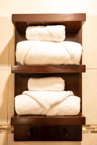 a stack of white towels on a shelf in a bathroom at Gamaí Monteverde Tiny House in Monteverde Costa Rica