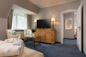 a living room with a television on a wooden dresser at Landhaus Carstens in Timmendorfer Strand