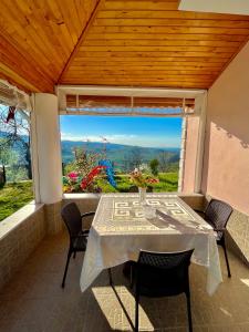 a table and chairs on a patio with a large window at Nature Family House in Arsin