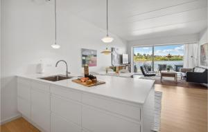 uma cozinha branca com um lavatório e uma sala de estar em Beach Front Apartment In Snderborg With Wifi em Sonderborg