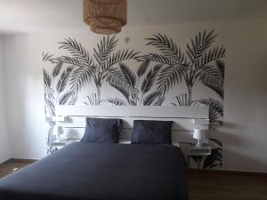 1 dormitorio con 1 cama con un mural de palmeras en Veronique schouckens en Binche